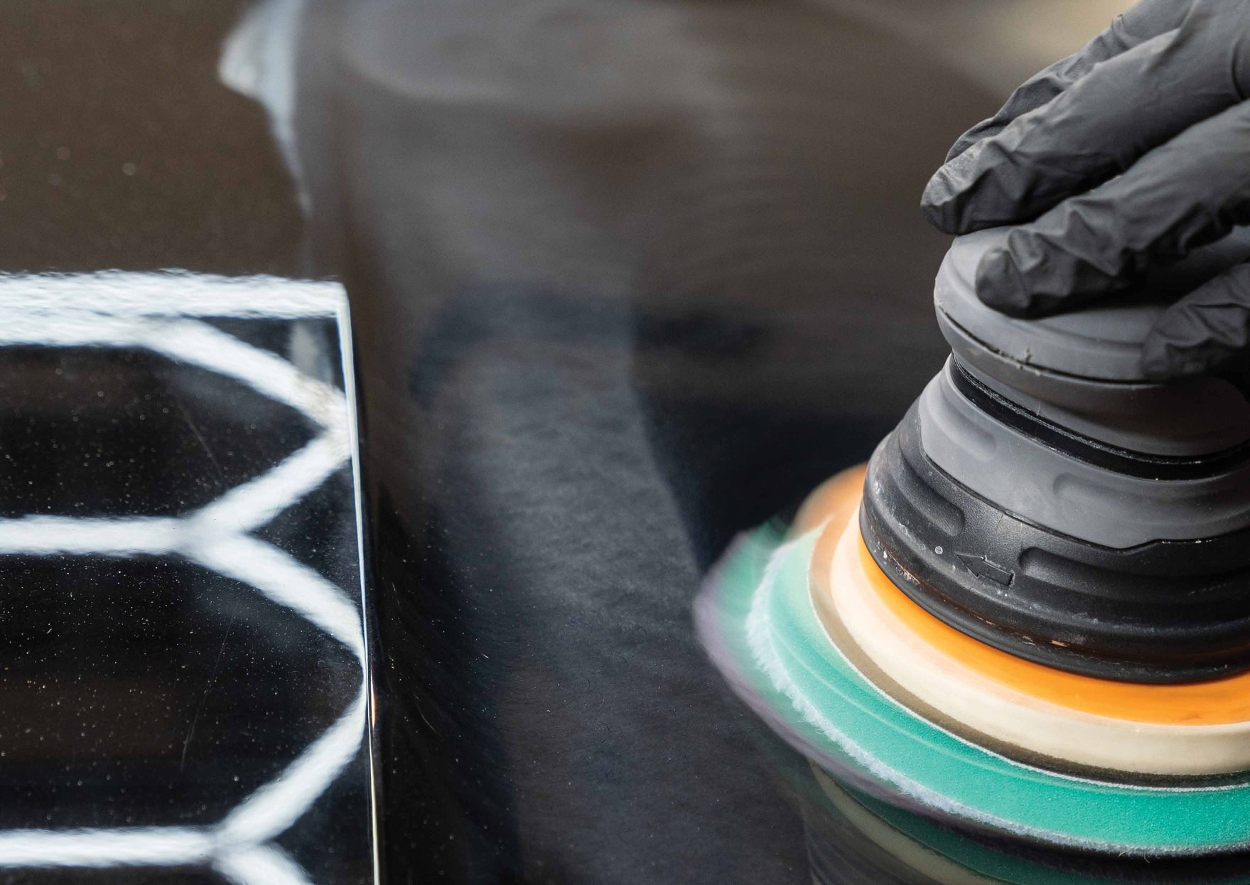Professional finishing work with polisher on a painted surface